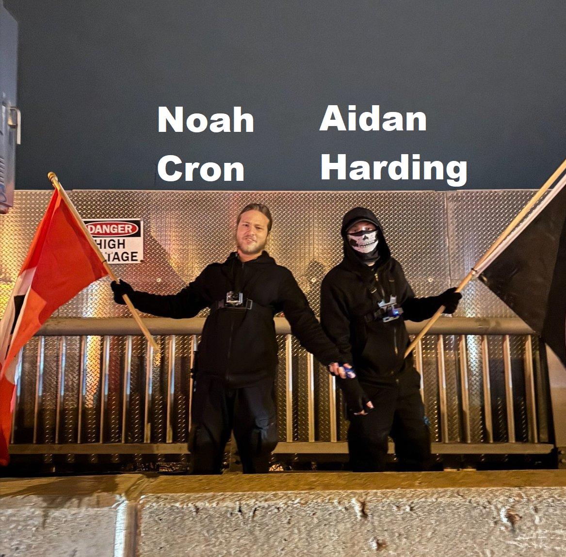 a man with blond hair holds his arms wide with mace and a nazi flag in his hands. a second man, dressed in black, wearing a skull balaclava, holds a black flag. the blond man has "noah cron" over his head in large white font and the masked man has "aidan harding" written over his